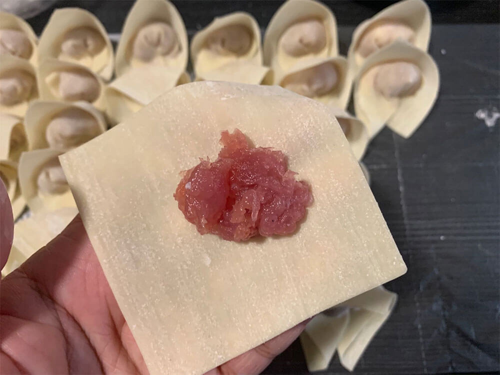 拿一张云吞皮,放上适量的肉馅