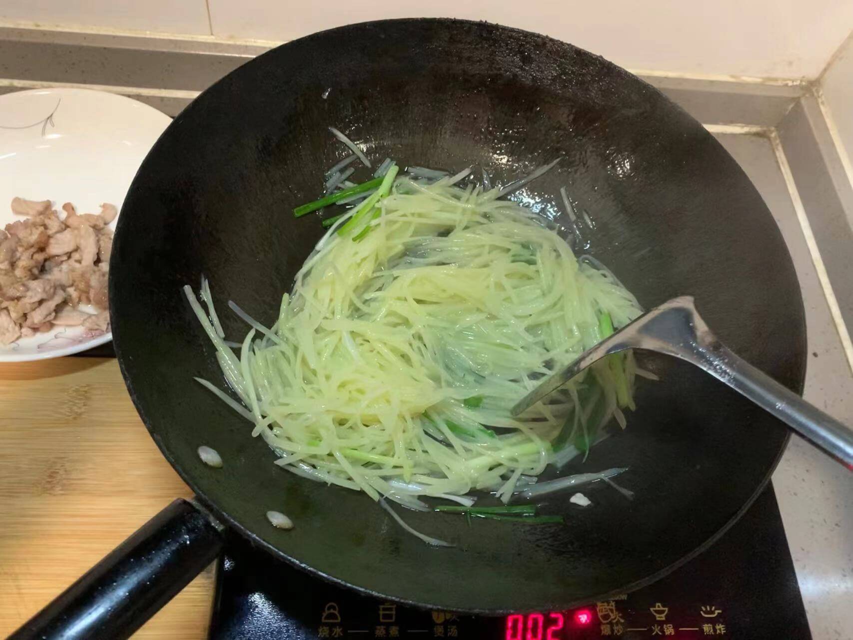 下葱段继续翻炒到土豆丝熟