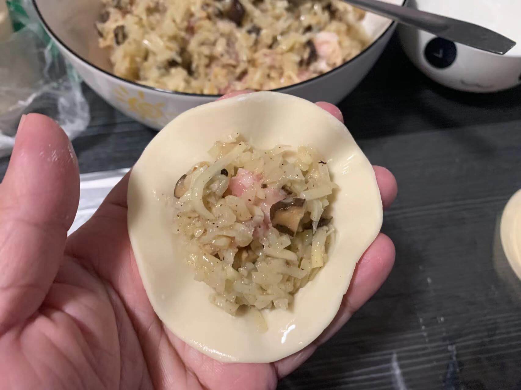 手指沾点清水涂一圈,勺子舀点馅,放在饺子皮中间